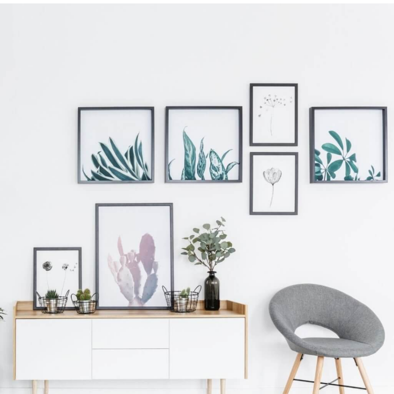 Room with various picture frames, a cozy chair and a small desk