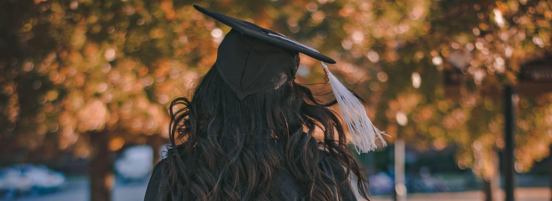 Girl walking with graduation cap and gown
